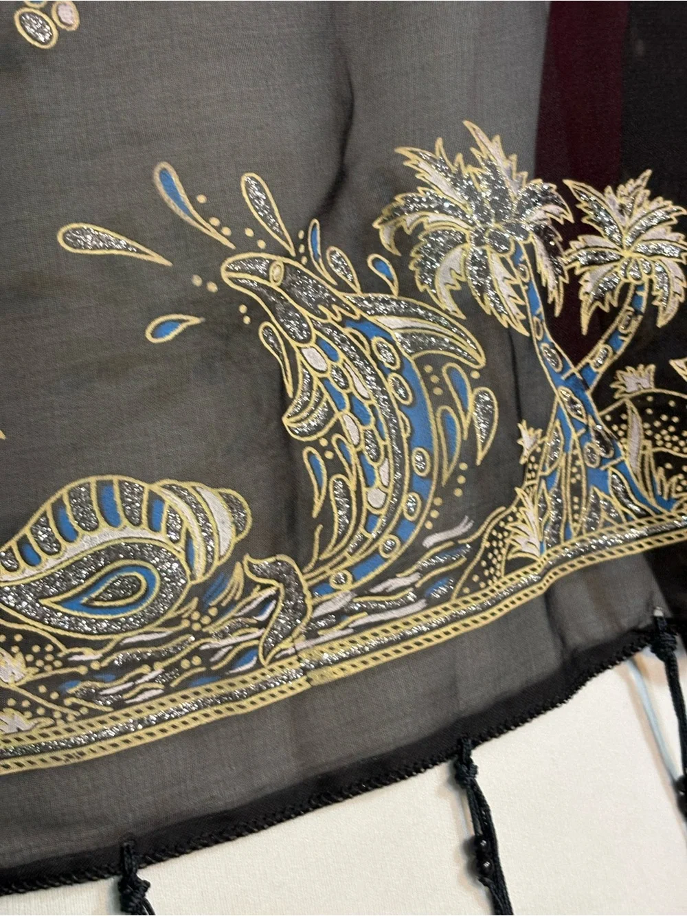 magenta and black scarf features palm tree motifs and black tassels along the ed